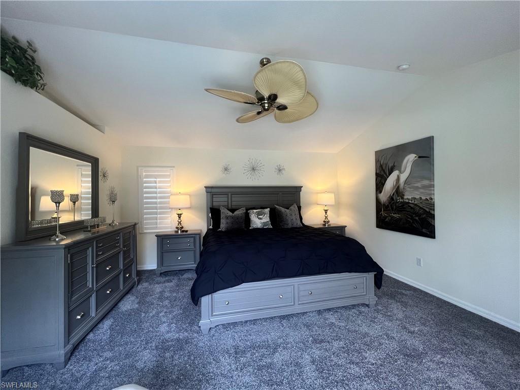 Master Bedroom with grey carpeting, ceiling fan, and vaulted ceiling