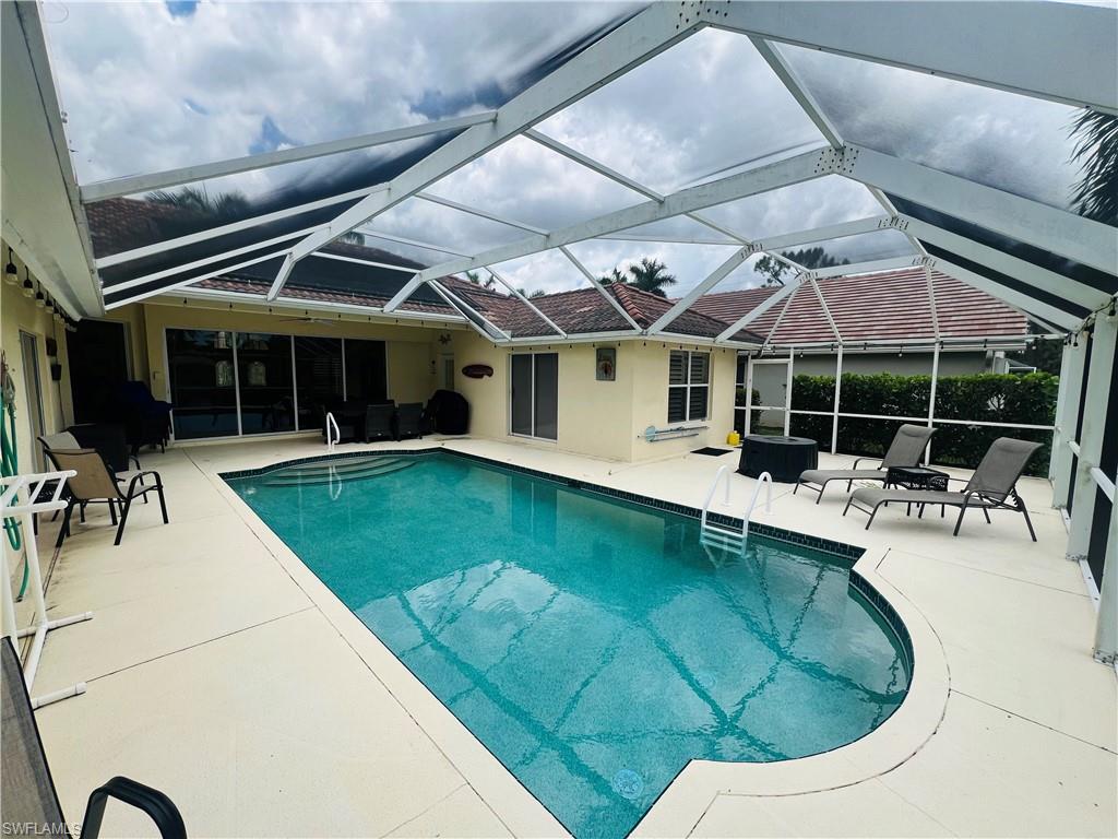 View of swimming pool featuring a patio area and a lanai
