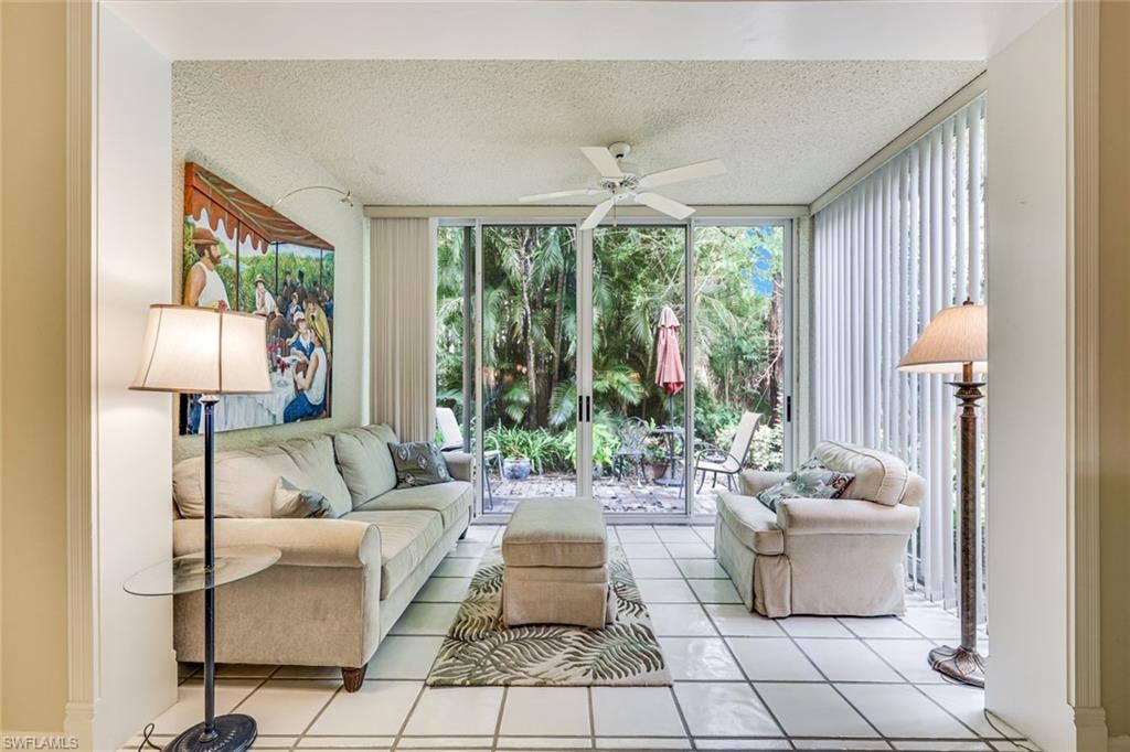 DEN AREA WITH IMPACT GLASS SLIDING DOORS WITH A VIEW OF THE OUTSIDE PATIO
