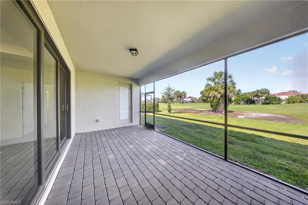 Screened patio featuring paver flooring, overhead lighting, and sliding glass doors