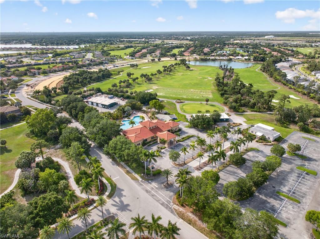 Aerial perspective showcasing a vibrant community with a central clubhouse featuring a barrel tile roof and an adjacent swimming pool