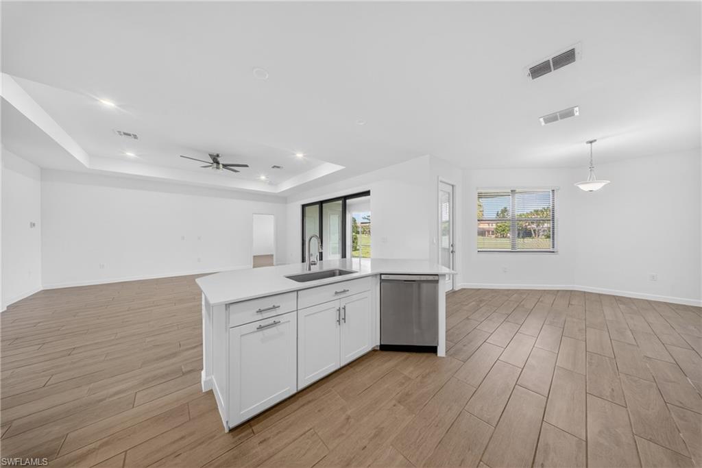 Modern kitchen island featuring a stainless steel sink, gooseneck faucet, and integrated dishwasher