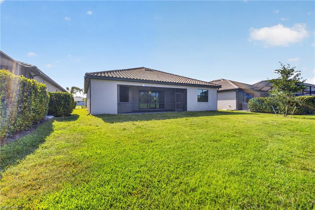 Expansive green lawn with a contemporary exterior featuring a screened lanai