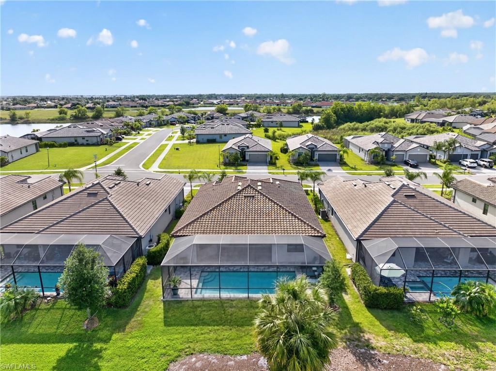 Aerial perspective of a neighborhood featuring multiple properties with screened pools