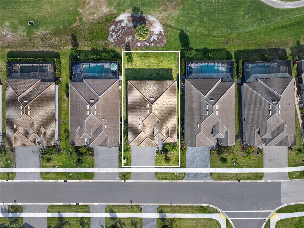 Aerial perspective showcasing a residential property with a shingle roof and a green lawn