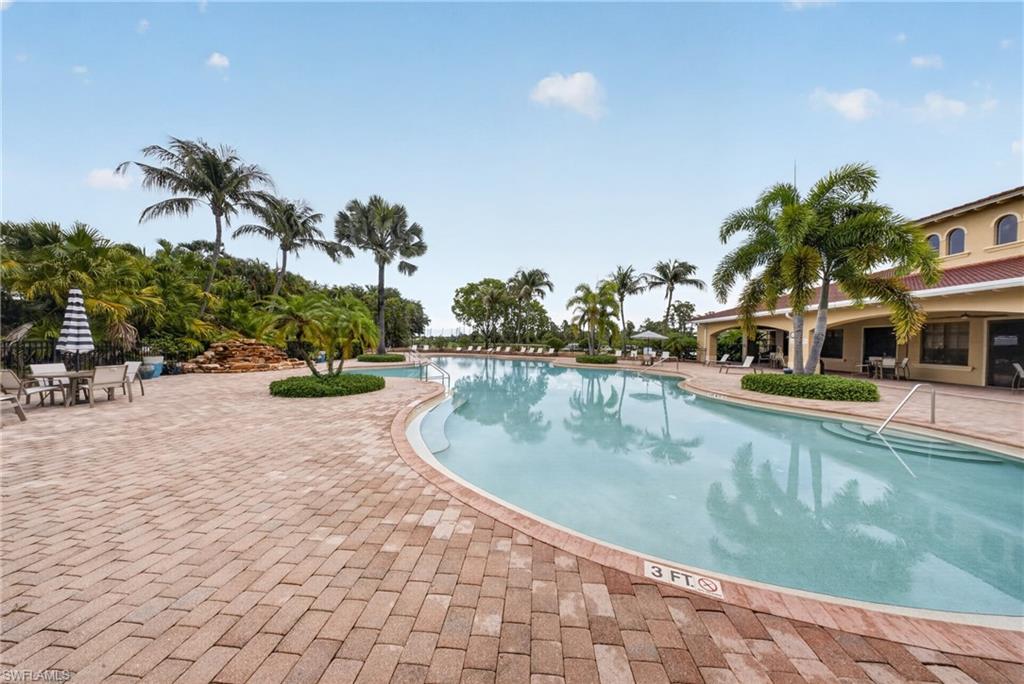 Expansive swimming pool with integrated steps, surrounded by a large paver patio
