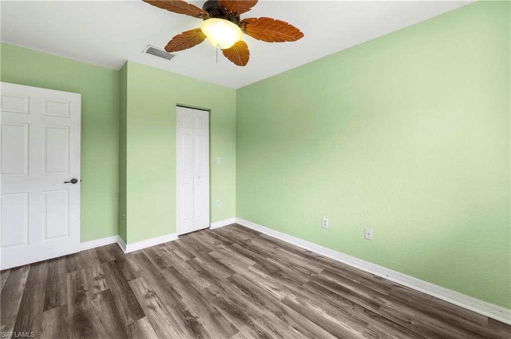 Room featuring wood-finish flooring, light green painted walls, and white trim