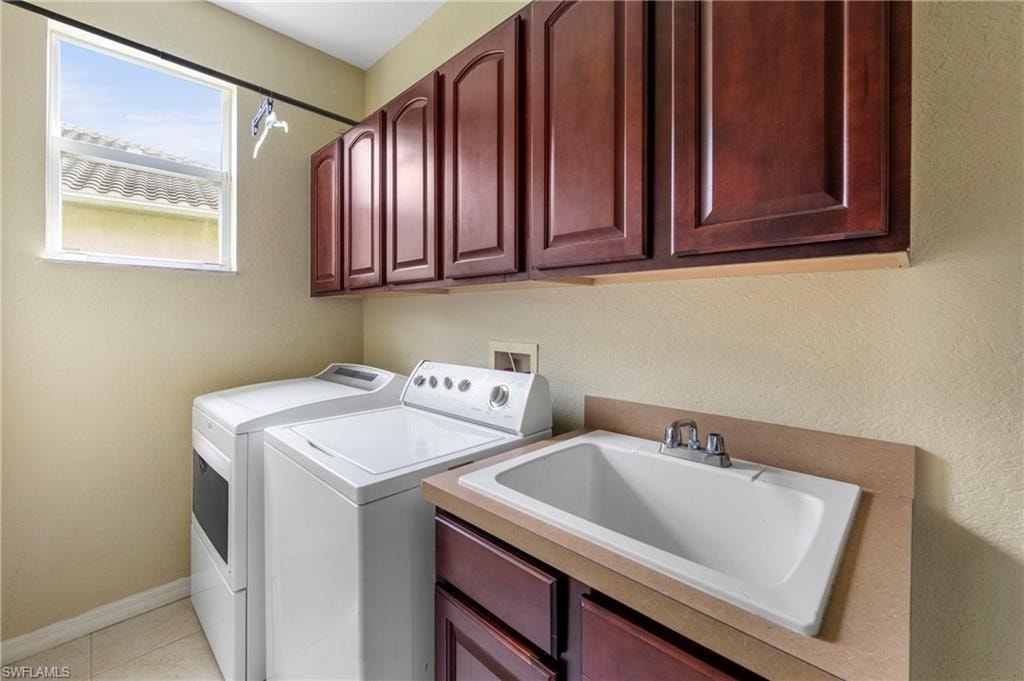 Utility room featuring a window, overhead cabinetry, and a built-in sink with base cabinetry