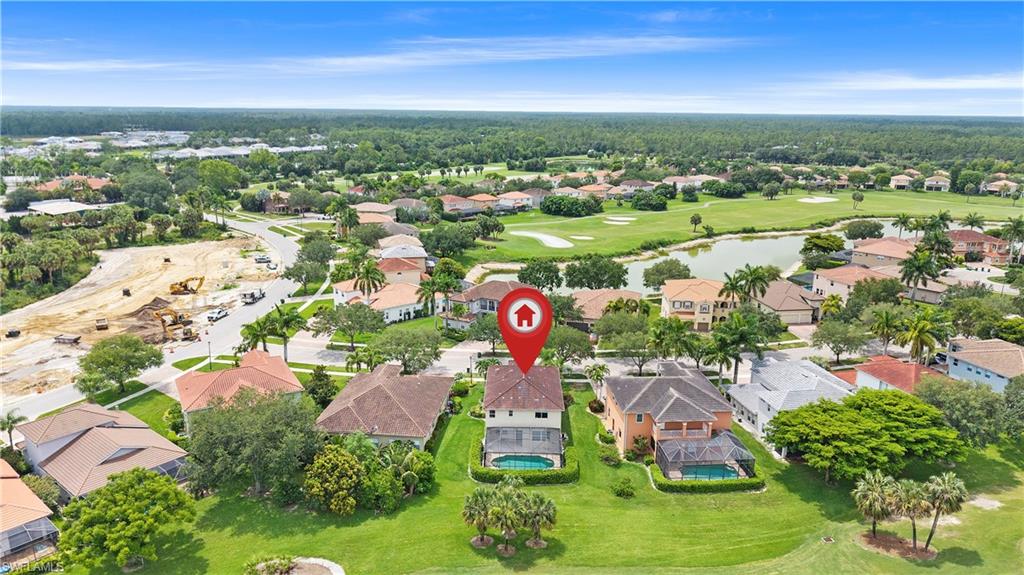 Aerial perspective showcasing a residential property with an attached swimming pool, surrounded by green lawns and mature trees