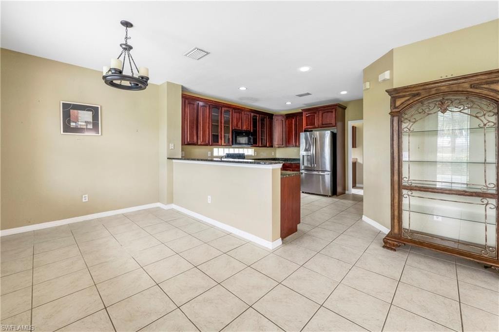 Kitchen with rich wood cabinetry, stainless steel appliances, and a granite-style countertop
