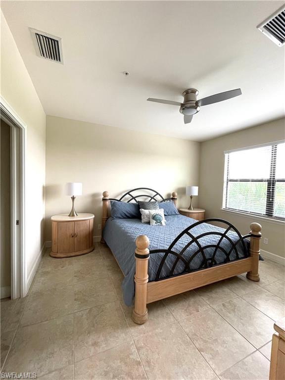 Bedroom featuring visible vents, baseboards, ceiling fan, and light tile patterned floors