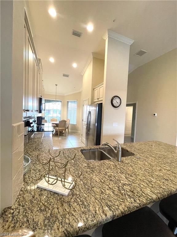 Kitchen featuring a breakfast bar area, visible vents, a sink, and appliances with stainless steel finishes