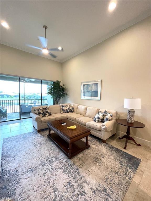Living area featuring ornamental molding, ceiling fan, baseboards, and tile patterned floors