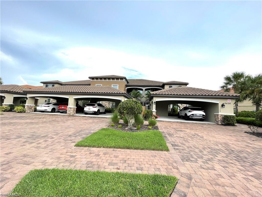 Mediterranean / spanish-style house with stucco siding, a tiled roof, and stone siding