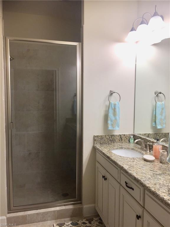 Full bathroom featuring a stall shower and vanity