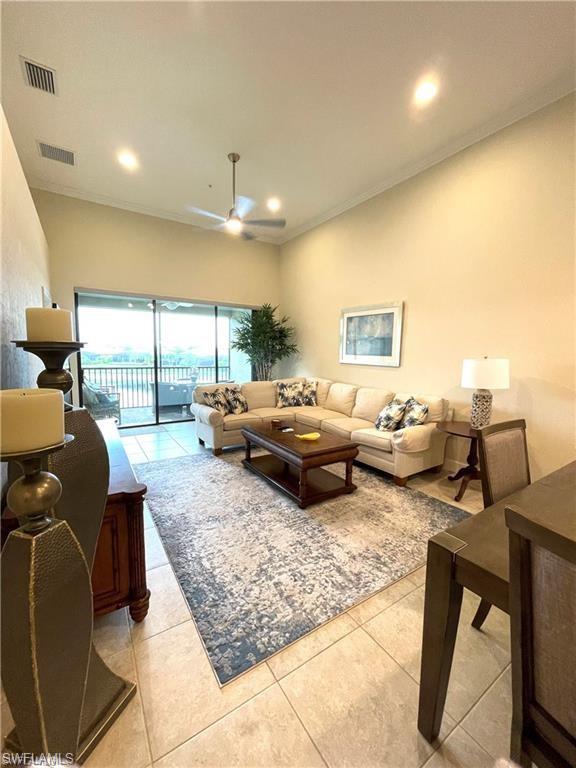 Tiled living area with ornamental molding, visible vents, and recessed lighting