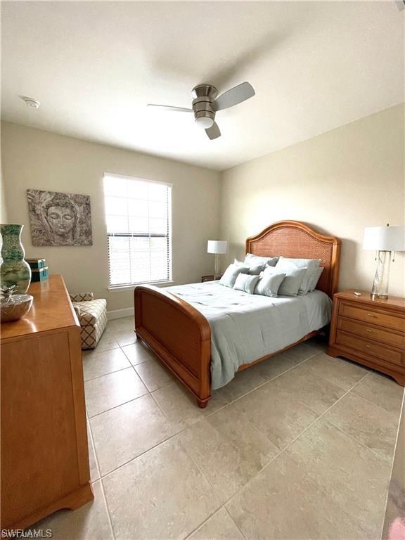 Bedroom with light tile patterned floors and a ceiling fan