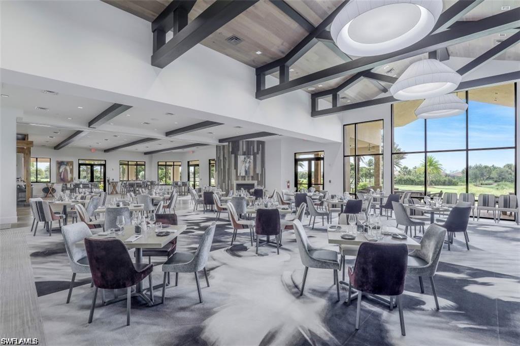 Dining space with beam ceiling, a high ceiling, and visible vents