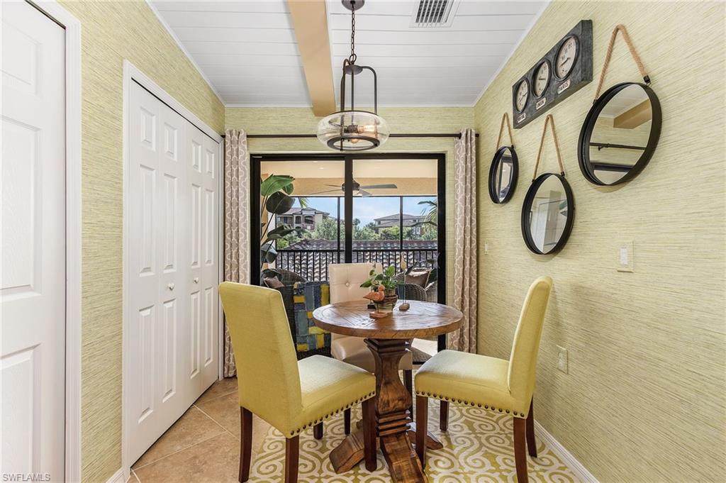 Dining room with tile patterned floors and wallpapered walls