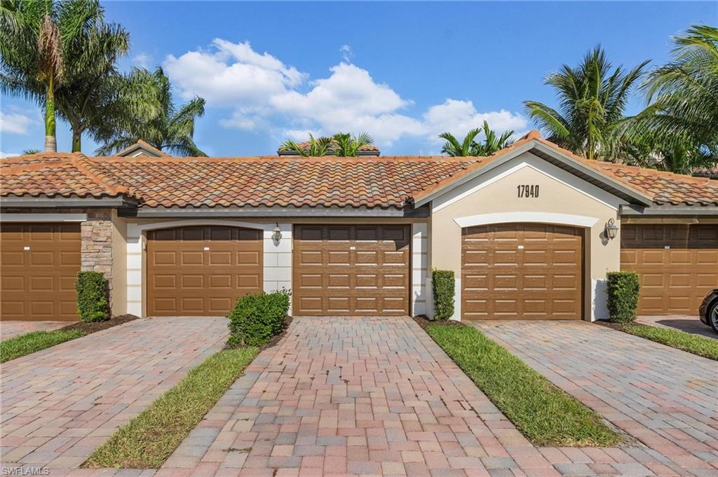 Mediterranean / spanish home featuring community garages, stucco siding, a tile roof, and stone siding
