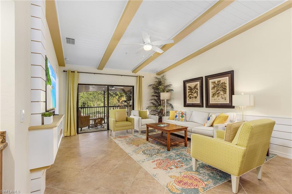 Living room with light tile patterned floors and a ceiling fan