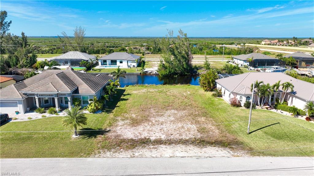 Cleared residential lot featuring street frontage, partial grass coverage, and canal access