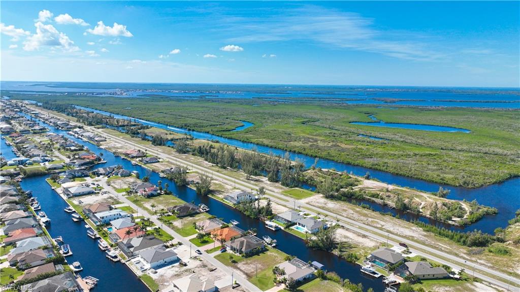 Aerial perspective showcasing a residential area with extensive canal frontage, numerous properties featuring private boat docks, and direct access to waterways