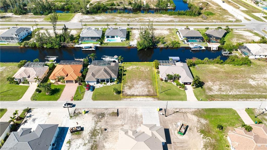 Cleared building lot featuring a canal-front location, street frontage, and surrounded by developed properties