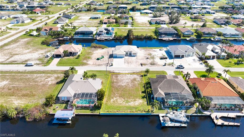 Vacant canal-front lot featuring clear land, a defined property boundary, and direct water access