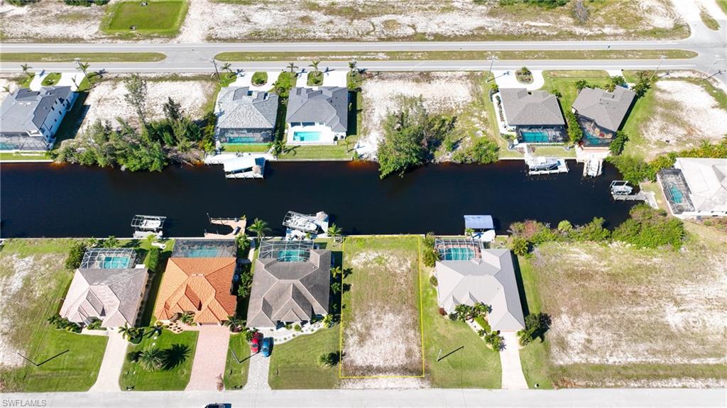 Waterfront residential lots with canal access, featuring established homes with private pools and boat docks