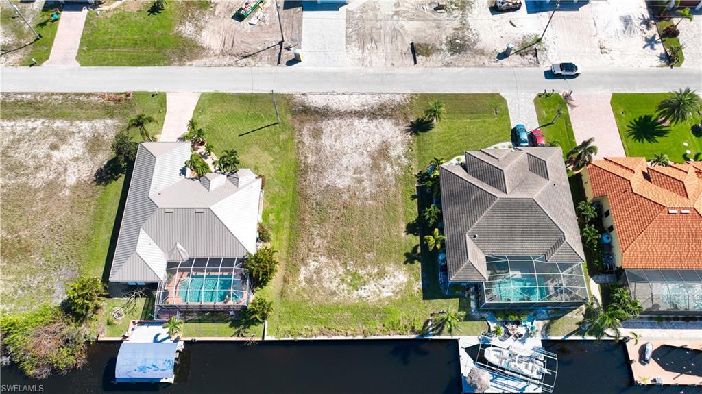 Expansive cleared lot bordered by paved roadways and existing residential properties