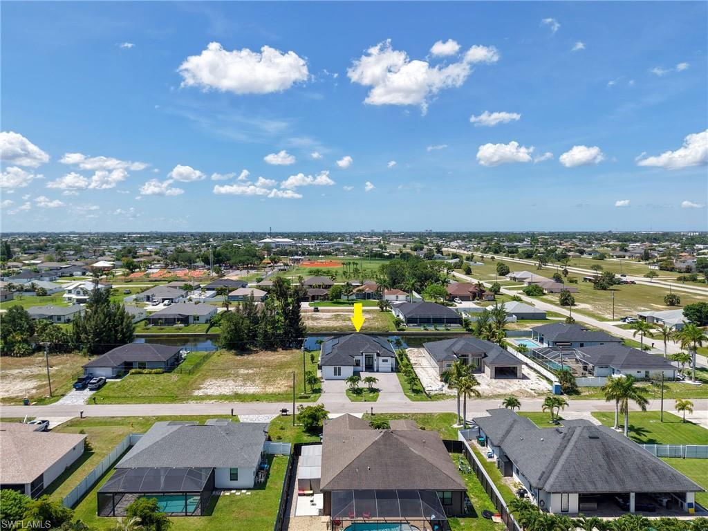 Aerial perspective showcasing the property with a white exterior and dark roof
