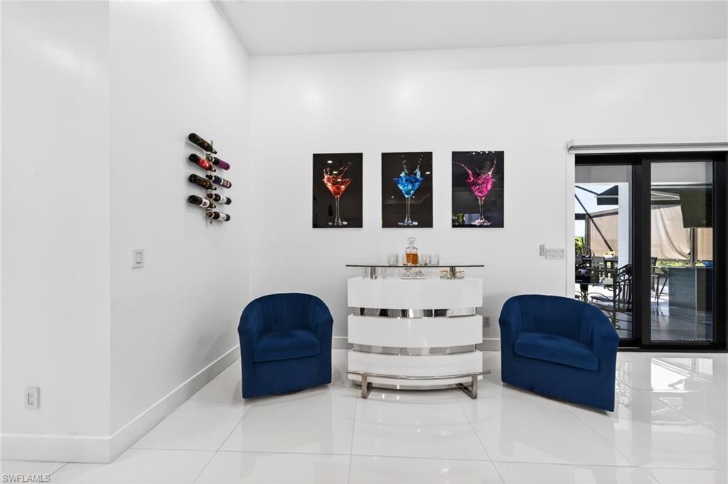 Glossy tile flooring complements a contemporary white bar with metallic accents