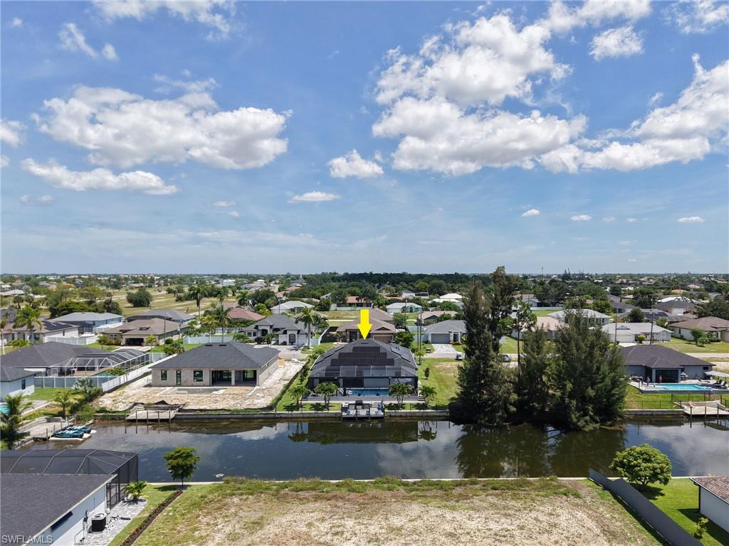 Waterfront property featuring a screened-in pool enclosure, private boat dock, and a dark shingle roof