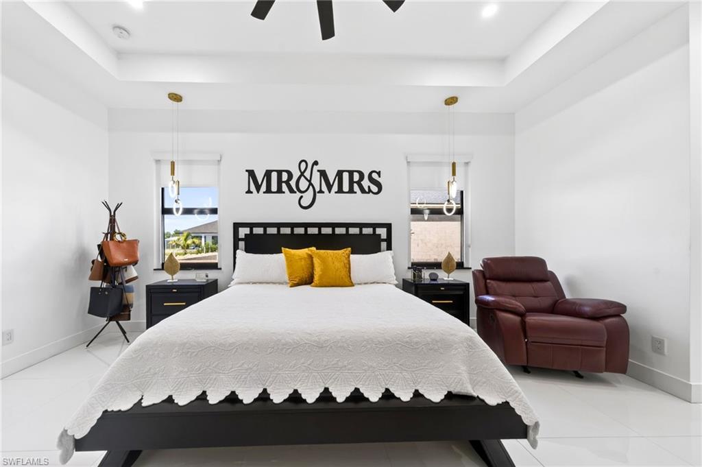Spacious interior with tray ceilings, recessed lighting, and white tile flooring