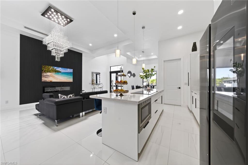 Open-concept living space featuring high ceilings, white tile flooring, and recessed lighting