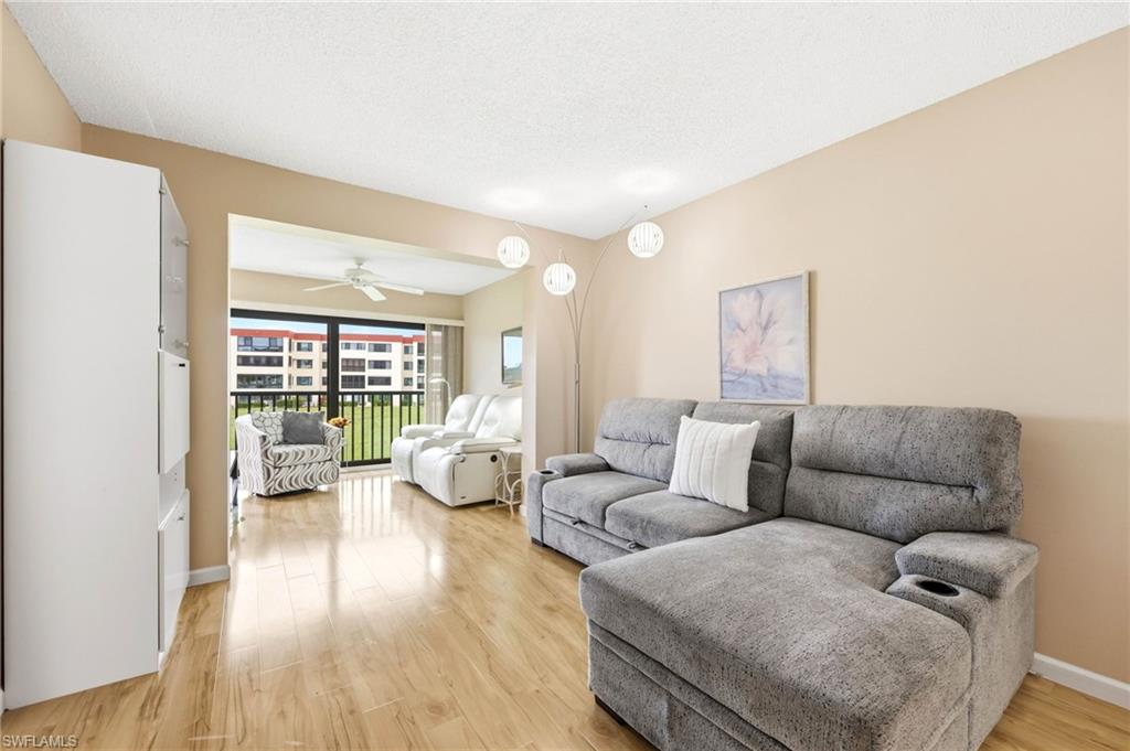 Open concept living area with wood-finish flooring, neutral wall tones, and a balcony with expansive outdoor scenery