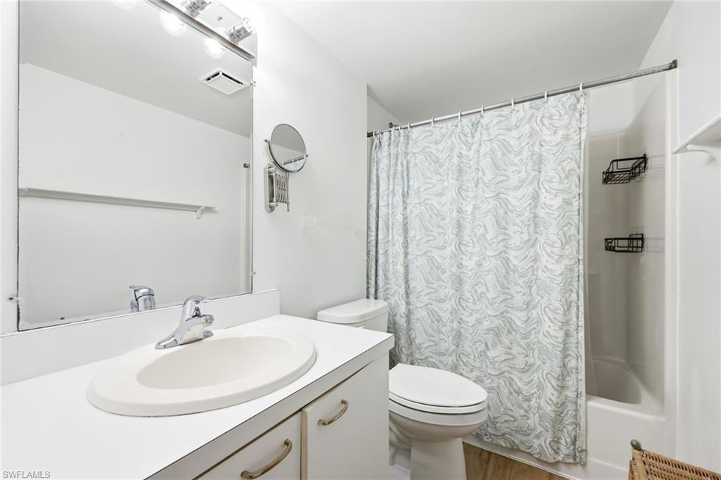 Bathroom featuring a white vanity with an integrated sink, a chrome faucet, and a large wall-mounted mirror