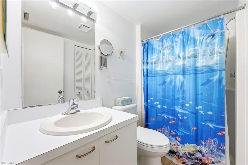 Bathroom featuring a white vanity with an integrated sink, chrome faucet, and under-sink storage