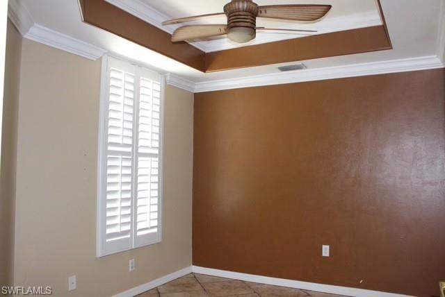 Room featuring a tray ceiling with a built-in ceiling fan, crown molding, and plantation shutters