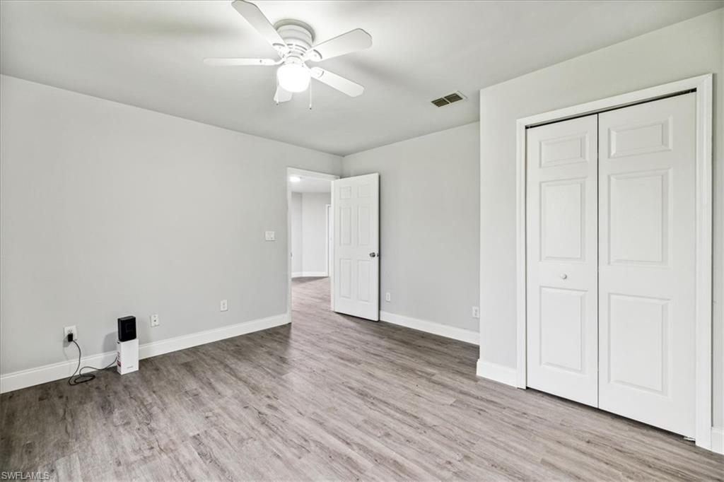 Unfurnished bedroom with ceiling fan, light hardwood / wood-style flooring, and a closet