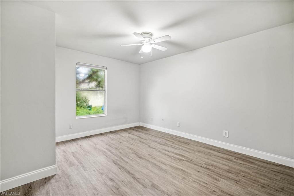 Empty room with light hardwood / wood-style floors and ceiling fan