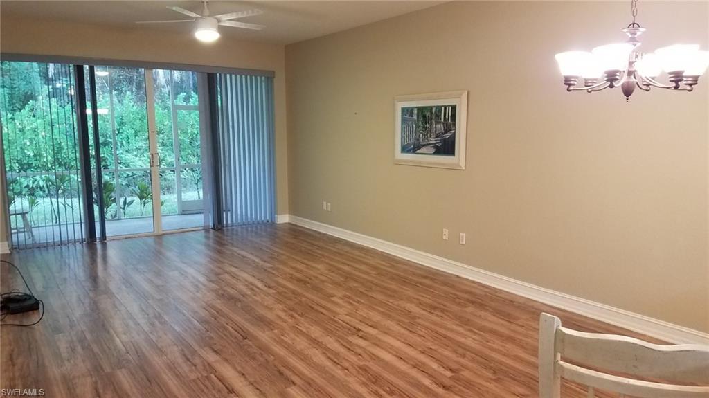 Unfurnished room featuring hardwood / wood-style floors and ceiling fan with notable chandelier