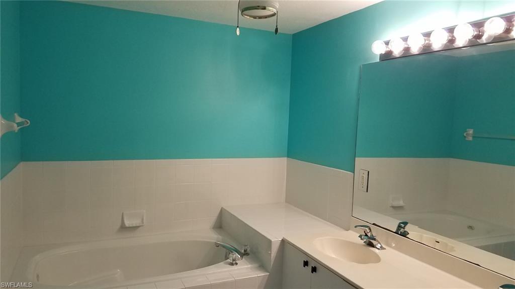 Bathroom featuring vanity and a relaxing tiled tub