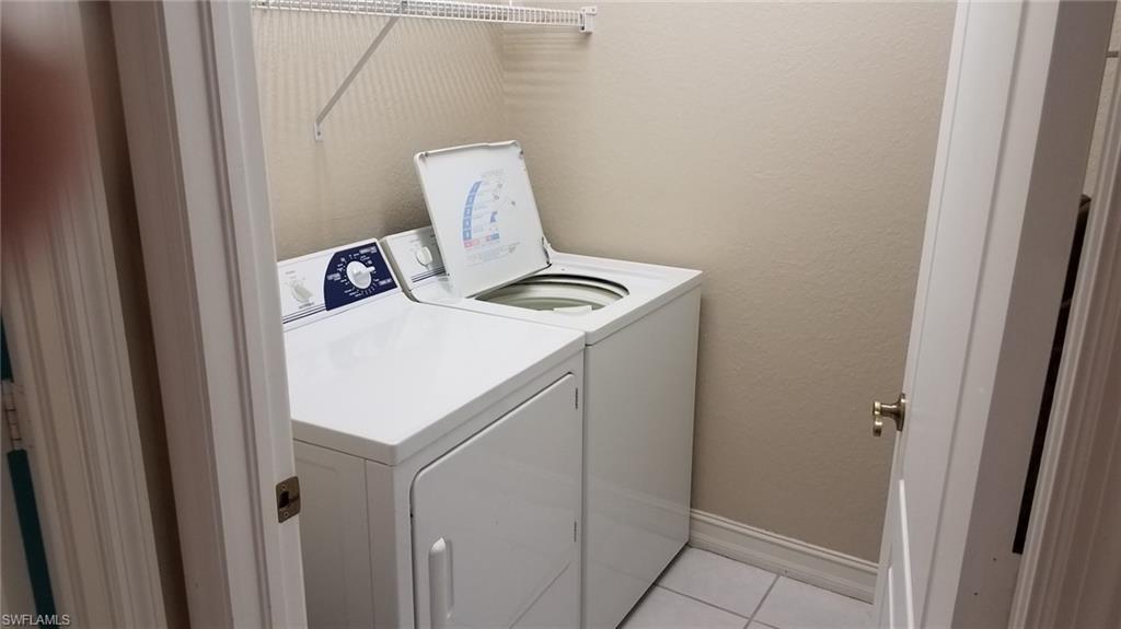Washroom featuring separate washer and dryer and light tile patterned flooring