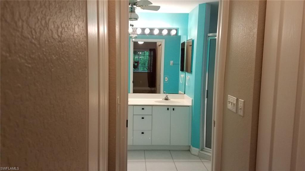 Bathroom with tile patterned flooring, vanity, and ceiling fan