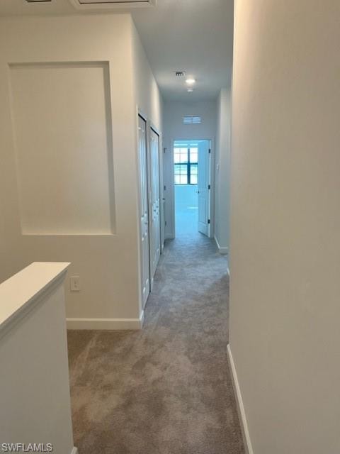 Hallway featuring carpet and baseboards