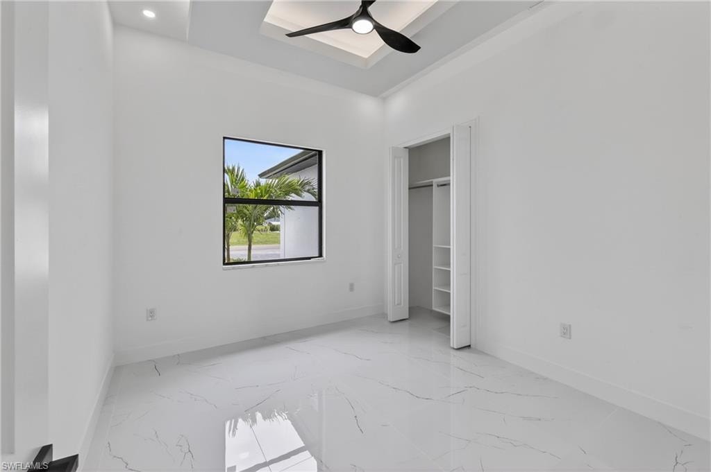 Bright room featuring white walls and large format marble-look tile flooring