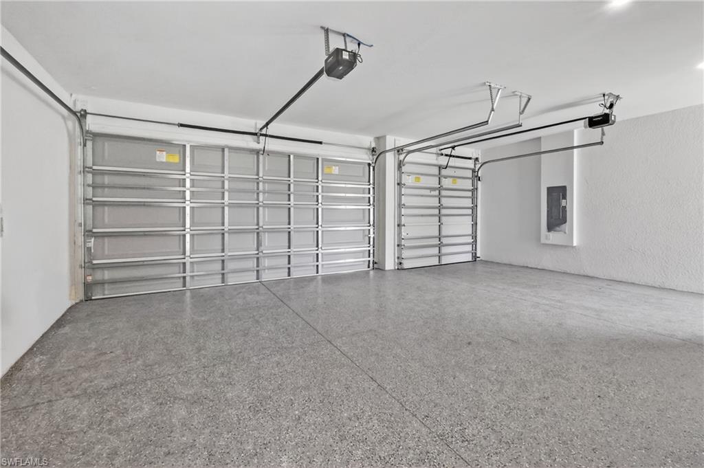 Garage featuring two overhead doors, automatic openers, and a speckled epoxy floor finish