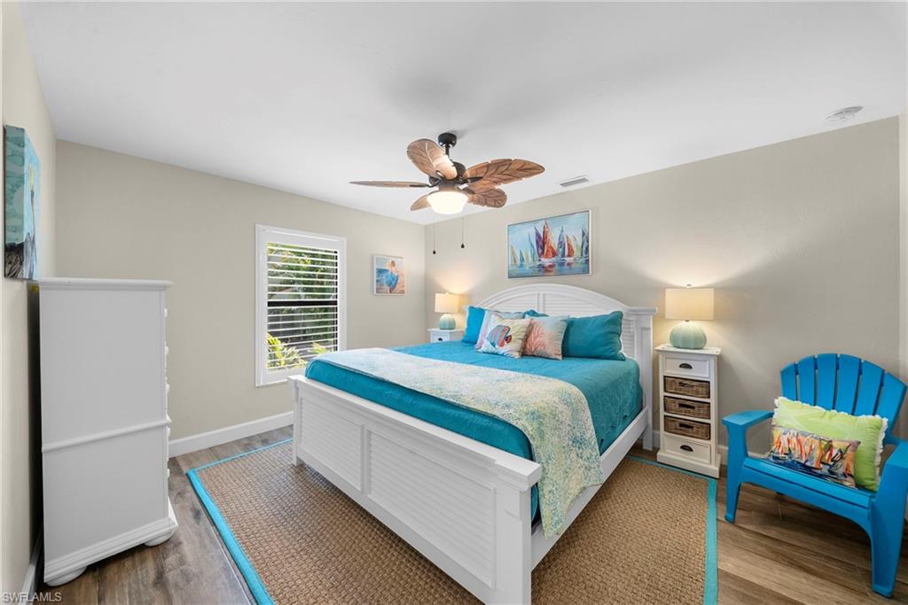 Bedroom with wood-finish flooring and a ceiling fan with integrated lighting